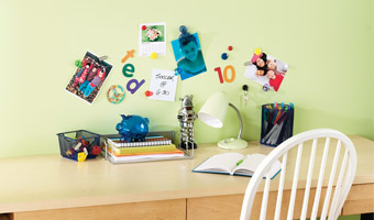 Photos and notes attached to a magnetic wall above a desk.