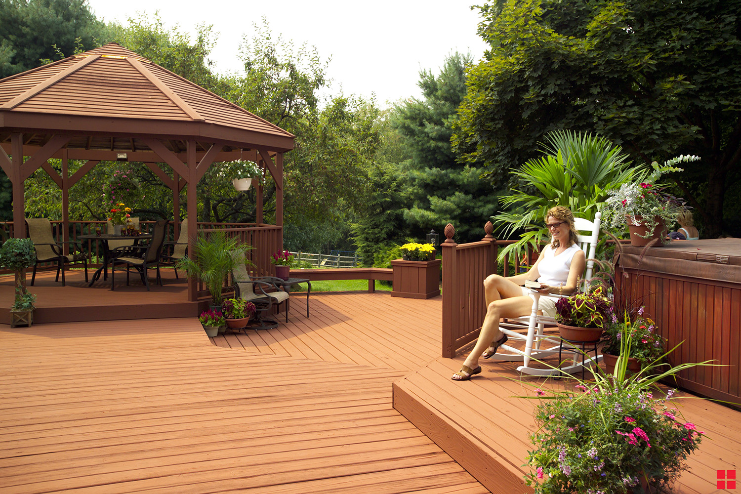 Woman sitting in a rocking chair on a newly stained wood deck.